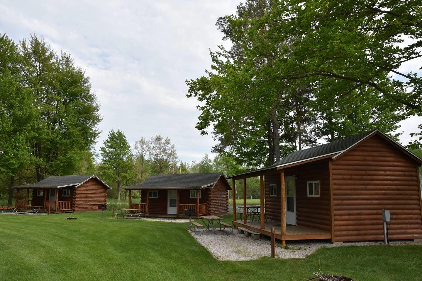 exterior of three rustic cabins by pond